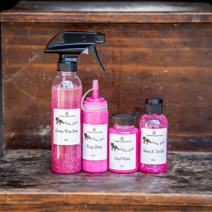 Set of pink spray bottles and containers on a wooden surface with a dark background