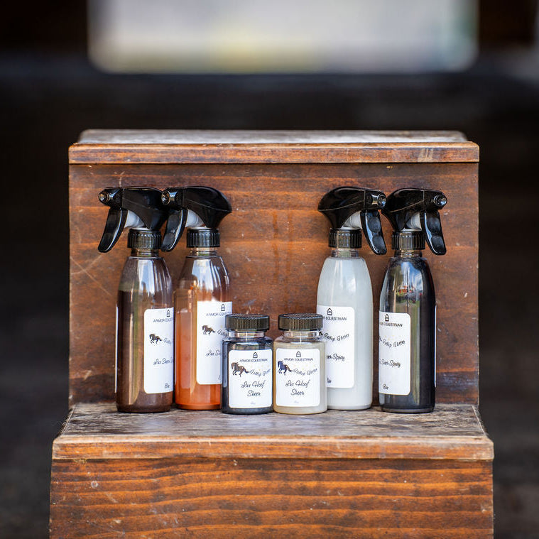 Set of spray bottles and small jars on a wooden block with a blurred background