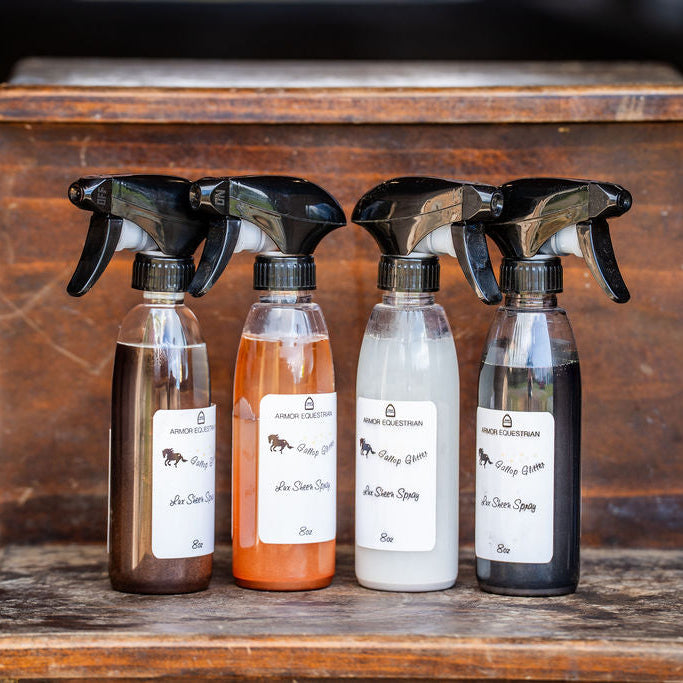 Four spray bottles with labels on a wooden surface