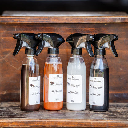 Four spray bottles with labels on a wooden surface