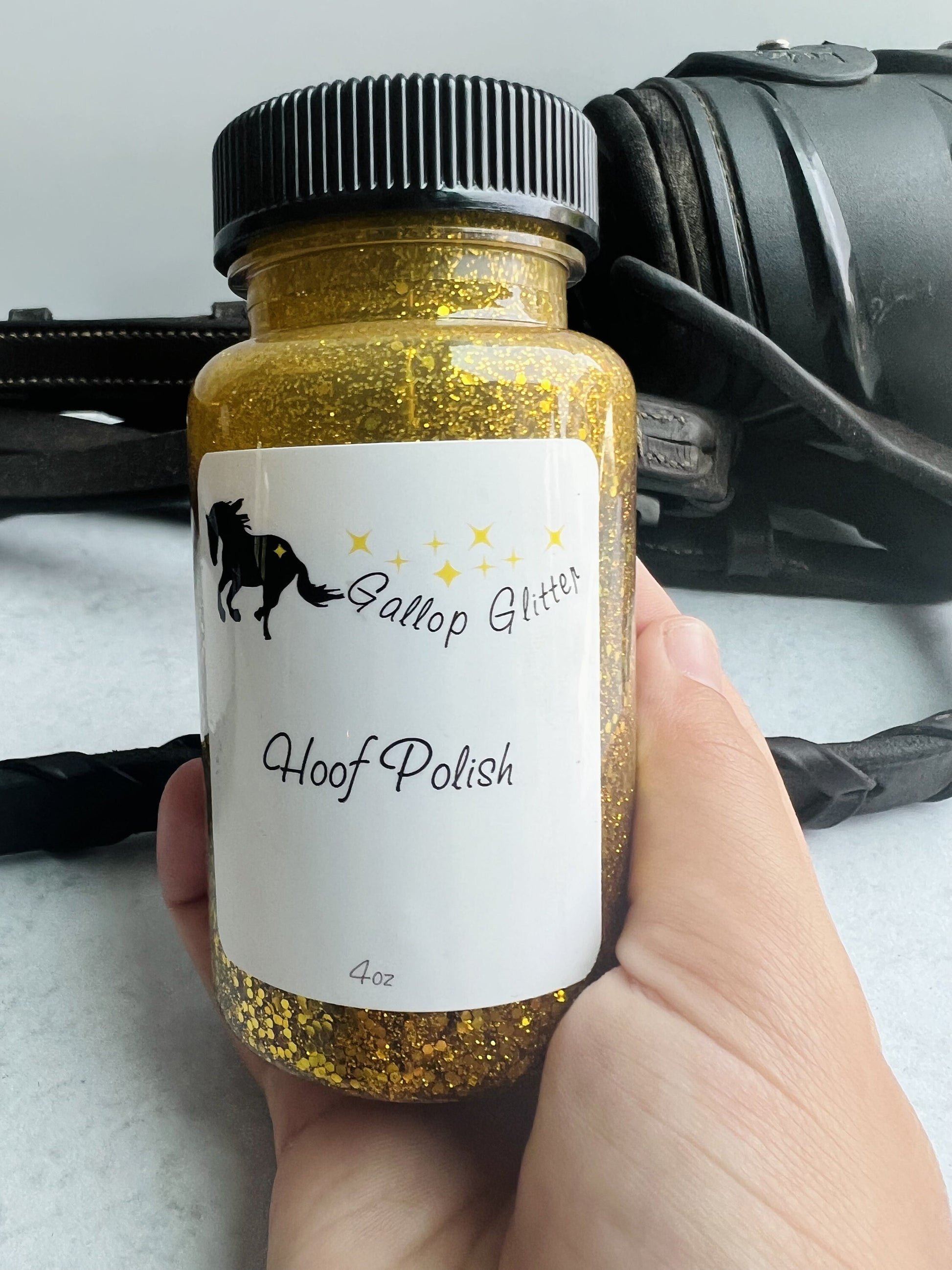 Gallop Glitter Gold Hoof Polish in hand to show scale