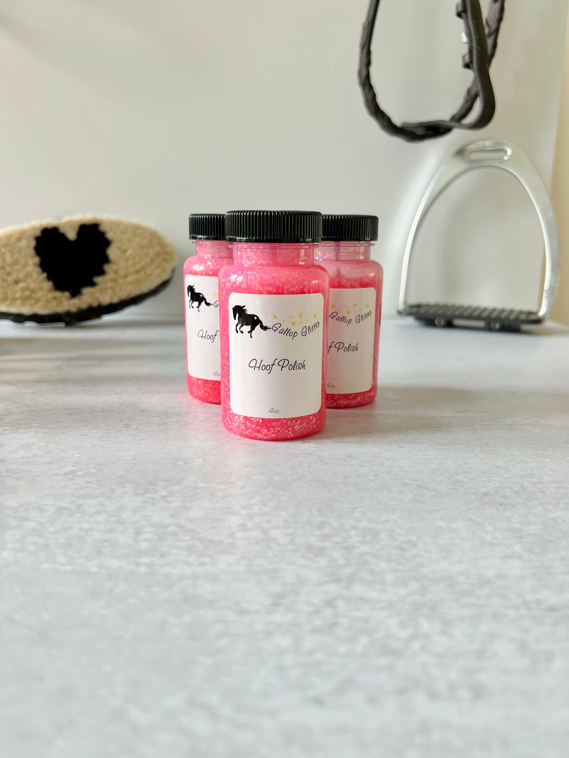 3 bottles of Gallop Glitter Pink Hoof Polish on backdrop